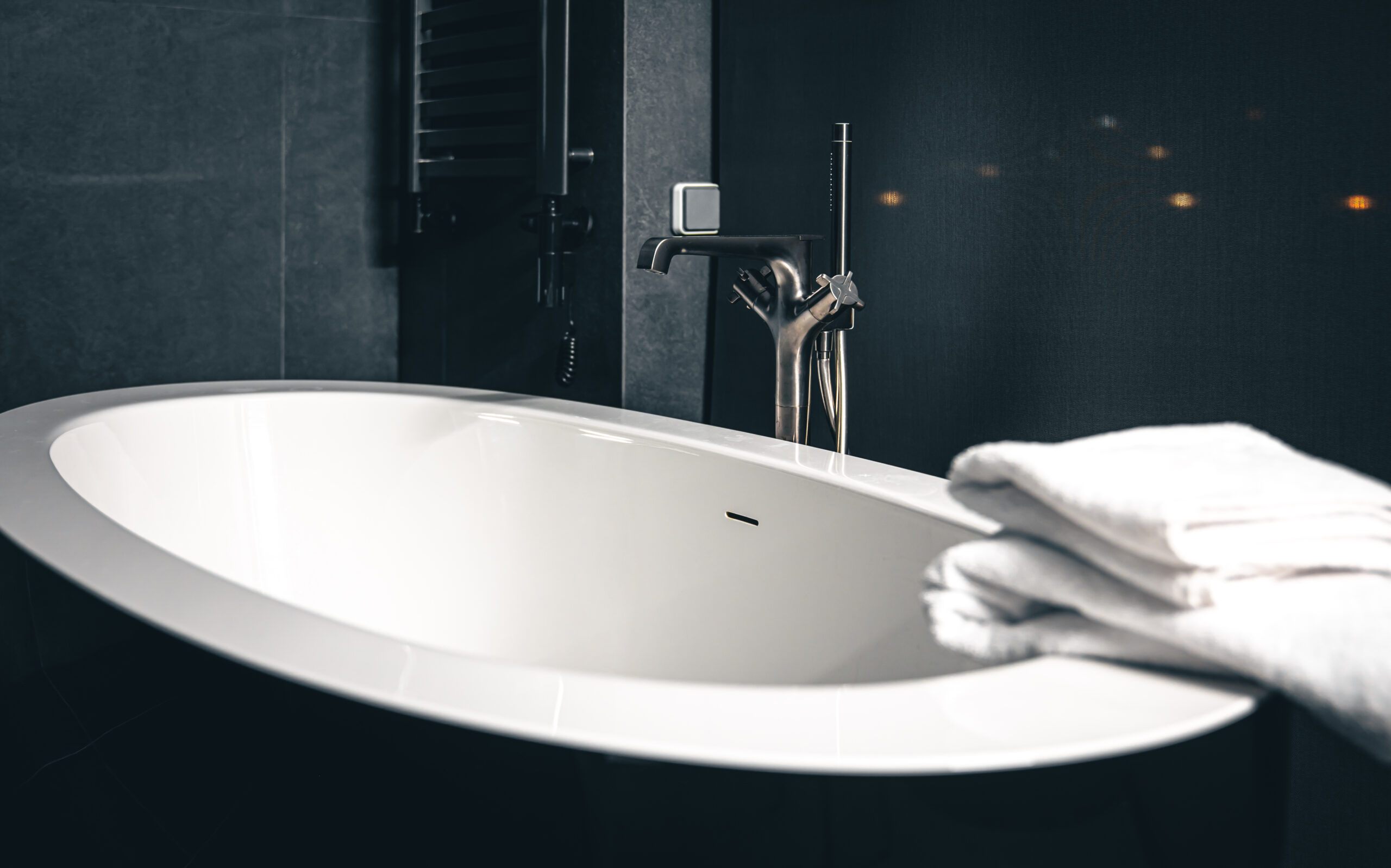 steel faucet and bathtub in bathroom interior with window.